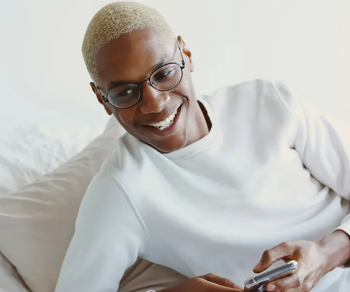 Homme souriant qui cherche un logement sur son téléphone